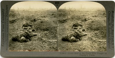 Carte stéréoscopique horizontale sépia montrant un champ ouvert avec quatre soldats écossais morts et des débris éparpillés. Numéro de stéréographe Keystone V18874. - Keystone View Company